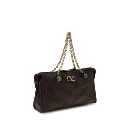 Medium Shoulder Bag by Valentino Garavani for women in bio-acetate & bos taurus calf leather brown, gold, chevron, signature & patchwork presents a versatile silhouette, showcasing a secure zipper and versatile single-compartment with versatile shoulder-strap, adjustable-strap & handle for a sophisticated look.