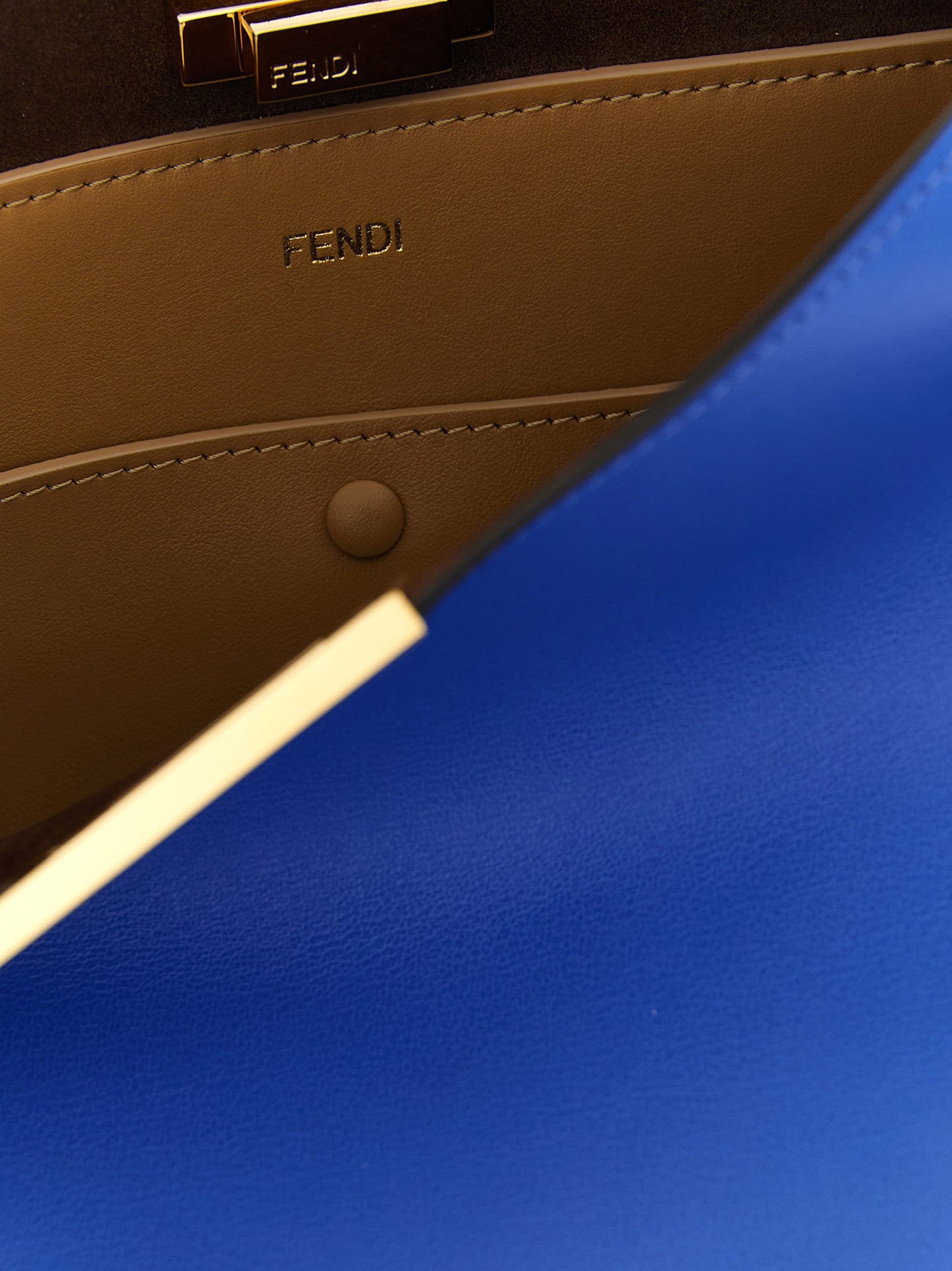 Medium Handbag by Fendi for women in calfskin leather blue & gold features an refined silhouette, showcasing a secure snap & button, ample , and versatile adjustable-strap & handle for a sophisticated refined aesthetic.