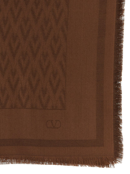 Scarf by Valentino Garavani for women in wool & silk brown, jacquard & signature presents a cosy silhouette, artfully capturing the sophisticated design and premium aesthetic of the V Logo Wool & Silk Rectangular Wrap Fringes Scarf.