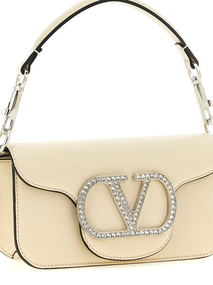 Small 2-in-1 Shoulder & Crossbody Flap Bag by Valentino Garavani for women in bos taurus suede calf leather white & signature features a enviable silhouette, showcasing a secure flap & magnetic, ample , and enviable crossbody-strap, shoulder-strap, detachable-strap & handle for a enviable finish.