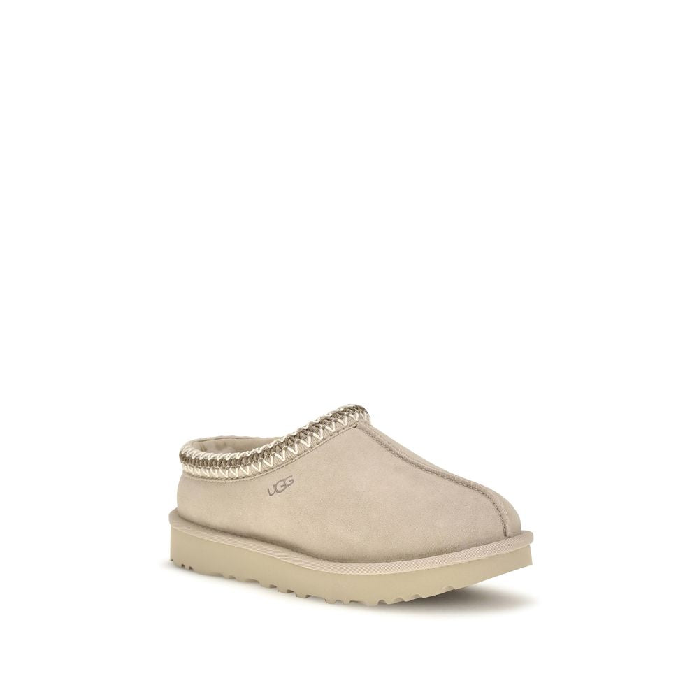Mules Flat Shoes by UGG for women in eva polyester suede leather beige & signature presents a impeccable silhouette as Women's EVA Polyester Suede Leather Mules Flat Shoes, artfully designed with a and a impeccable for a refined, upscale finish.
