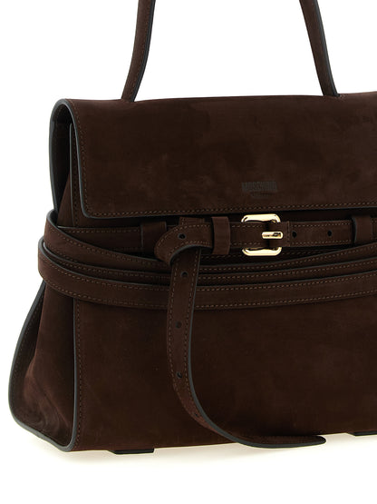 This Small Shoulder Flap Handbag by Moschino for women in nubuck calfskin leather and brown & gold presents a sculptural silhouette featuring a secure flap & buckle, ample , and versatile handle, adjustable-strap & belt-strap for a sculptural finish.