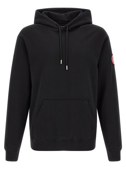 Sweatshirt Hoodie by Canada Goose for men in cotton terrycloth black features an dramatic silhouette, showcasing a sophisticated hooded neckline and dramatic for a refined, modern aesthetic.