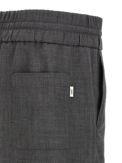 Trousers by Ami Paris for men in virgin wool gray & signature features a artisanal silhouette, showcasing a sophisticated relaxed-fit with a long and high rise for a artisanal finish.