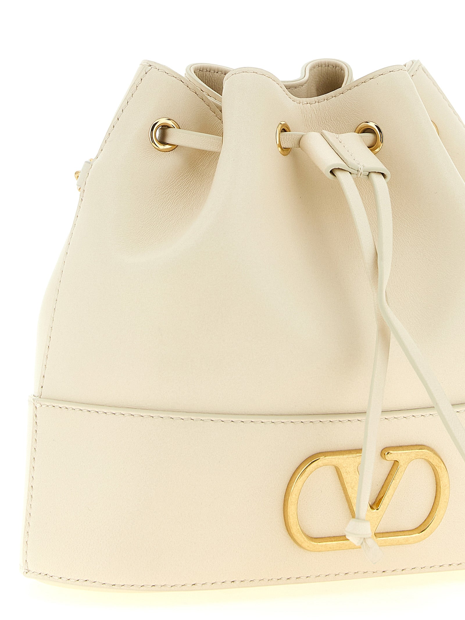 Medium Crossbody Bucket Handbag by Valentino Garavani for women in lamb leather gold, white & signature features a versatile chic silhouette, meticulously detailed with a secure drawstring & toggle, ample , and versatile crossbody-strap & shoulder-strap.