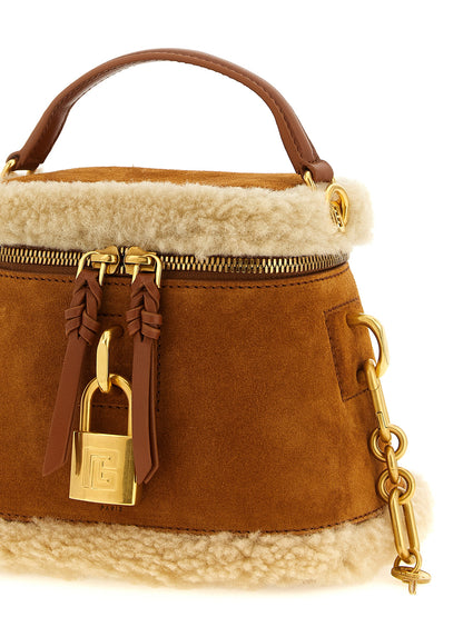 Vanity Handbag by Balmain for women in plush suede calfskin leather brown & gold features a signature silhouette, showcasing a secure zipper and signature with versatile shoulder-strap & handle for a sophisticated look.