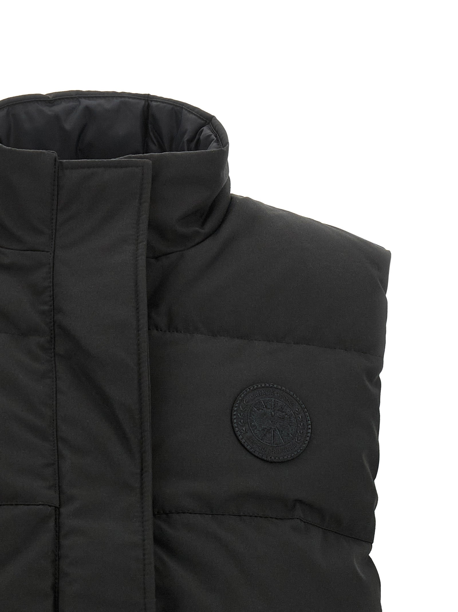 Vest by Canada Goose for women in cotton polyester black showcases a dynamic silhouette, perfectly balancing thermal & pockets with a dynamic high-neck neckline for a sophisticated, high-fashion look.