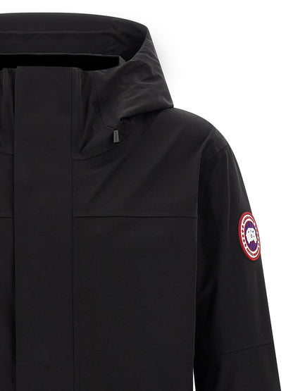 Hooded Rain Coat by Canada Goose for men in stretch polyamide black features an contemporary silhouette, showcasing a sophisticated hooded neckline and contemporary water-resistant, pockets, hooded & windproof for a premium, weather-ready look.