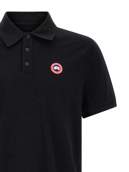 Polo Shirt by Canada Goose for women in cotton black presents a crisp silhouette, artfully detailed with a crisp and crisp asymmetric neckline.