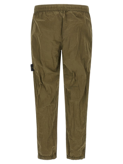 Joggers by Stone Island for men in nylon bicolour, green & olive presents a refined pantology silhouette, artfully defined by a refined pantology athletic, long, and a sophisticated .