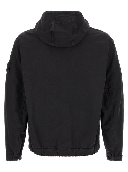 Hooded Windbreaker Jacket by Stone Island for men in cotton black presents a resilient silhouette, artfully detailed with a sophisticated hooded neckline and functional pockets, hooded & windproof for a resilient finish.