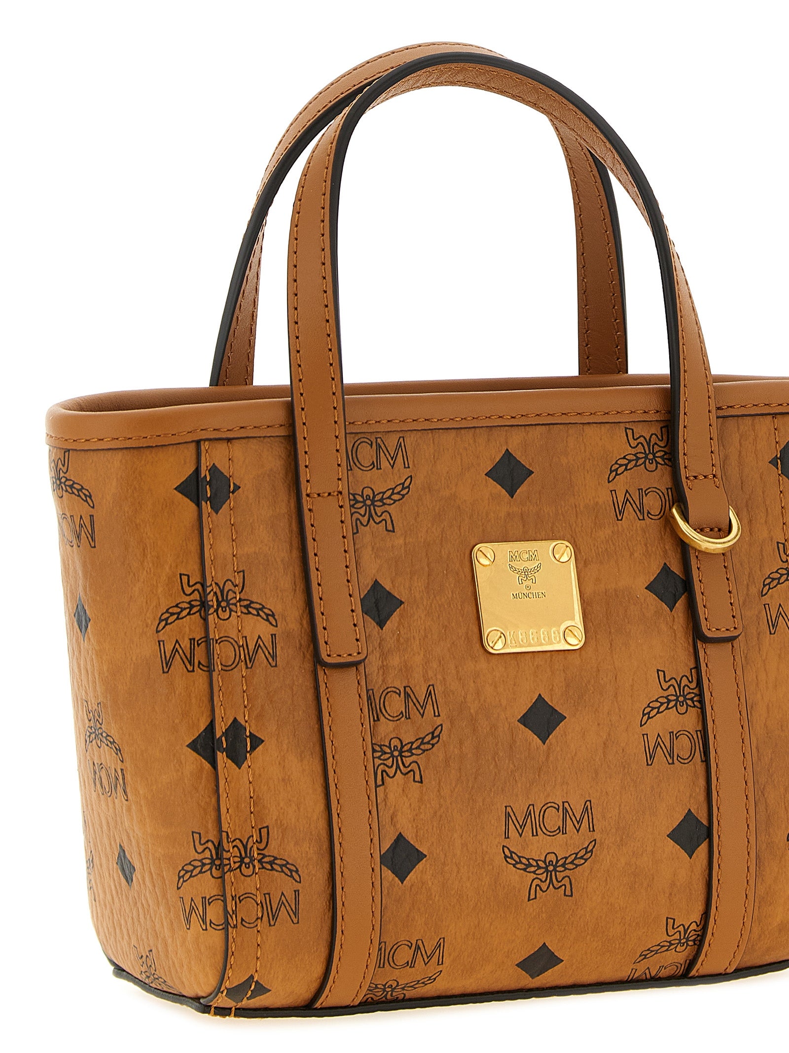 Mini Shopper Tote Bag by MCM for women in cotton canvas poly leather brown, gold, natural & monogram features an utilitarian-chic silhouette, showcasing the Visetos Cotton Canvas Poly Leather Mini Shopper Tote Bag design with a secure , ample , and versatile shoulder-strap & handle.