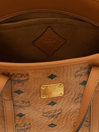 Small Shopper Tote Bag by MCM for women in polyester polyethylene polyurethane leather brown, gold, signature & monogram features a urban sophisticate Visetos Polyester Polyethylene Polyurethane Leather Small Shopper Tote Bag design with a secure zipper, ample , and versatile shoulder-strap, handle & adjustable-strap for a urban sophisticate finish.