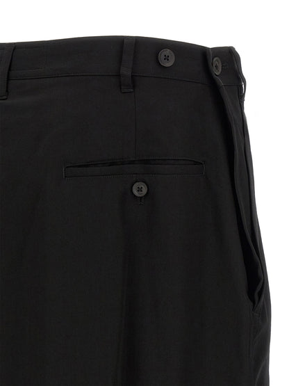 Trousers by Yohji Yamamoto for men in wool black presents a perennial silhouette, meticulously tailored with a wide cut, long finish, and an elegant .