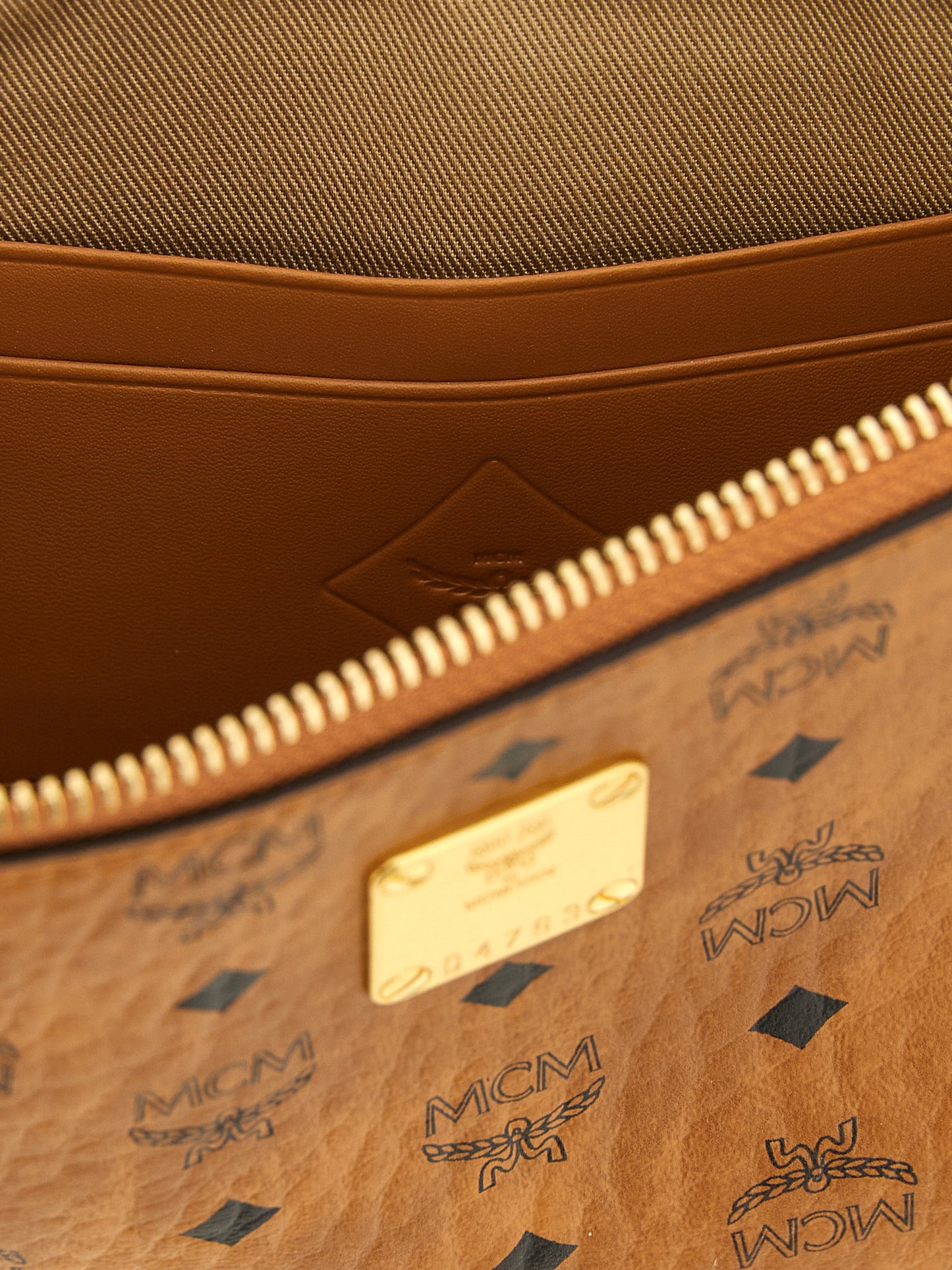 Mini Clutch Handbag by MCM for women in polyester polyethylene polyurethane leather brown, gold & monogram features a architectural silhouette, showcasing a secure zipper, ample , and versatile shoulder-strap & adjustable-strap for a architectural finish.
