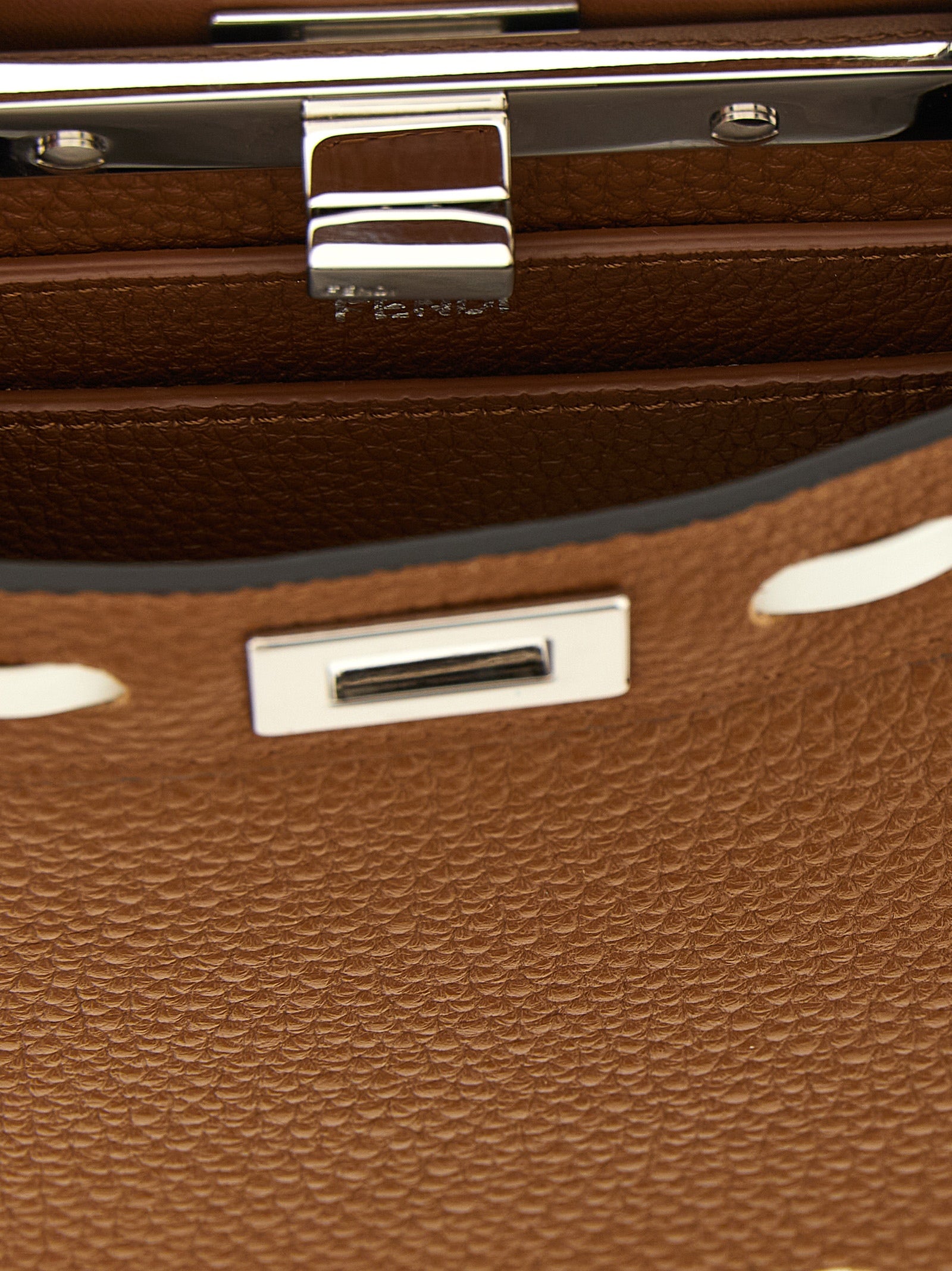 This Handbag by Fendi for women in calfskin leather and brown, silver & white presents a sculptural silhouette featuring a secure turn-lock, ample built-in-compartments, and versatile shoulder-strap, handle & adjustable-strap for a sculptural finish.