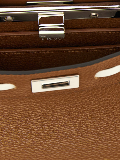 This Handbag by Fendi for women in calfskin leather and brown, silver & white presents a sculptural silhouette featuring a secure turn-lock, ample built-in-compartments, and versatile shoulder-strap, handle & adjustable-strap for a sculptural finish.