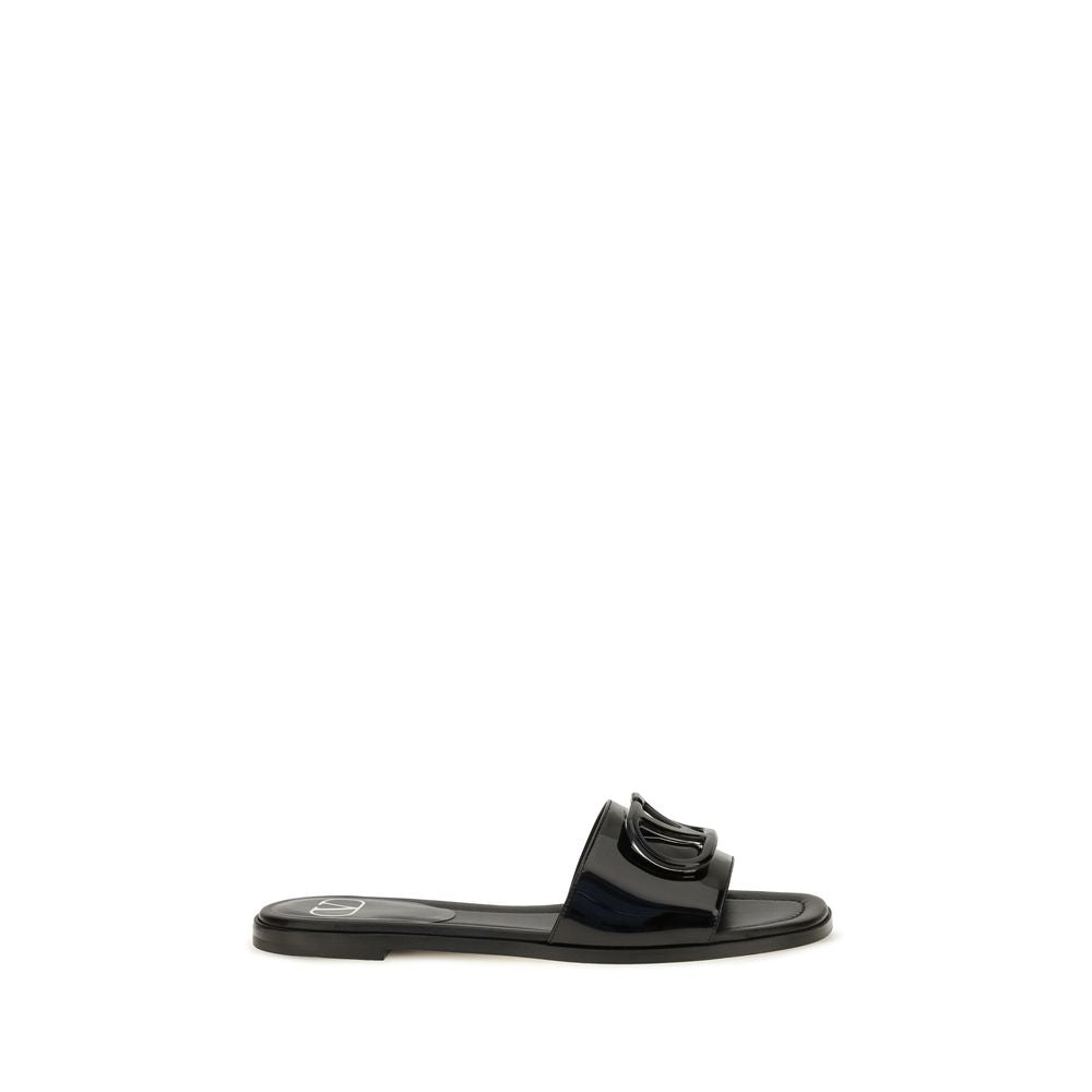 Flat Slider Sandals by Valentino Garavani for women in bos taurus calf patent leather black features an exquisite silhouette, showcasing the exquisite V Logo Women's Bos Taurus Calf Patent Leather Flat Slider Sandals with a flat and open toe style.