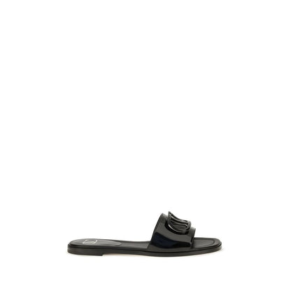 Flat Slider Sandals by Valentino Garavani for women in bos taurus calf patent leather black features an exquisite silhouette, showcasing the exquisite V Logo Women's Bos Taurus Calf Patent Leather Flat Slider Sandals with a flat and open toe style.