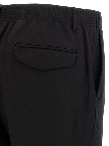 Trousers by CELLAR DOOR for men in virgin wool black features a sculptural silhouette, showcasing a sculptural tapered-leg and long with a sophisticated for a sculptural finish.