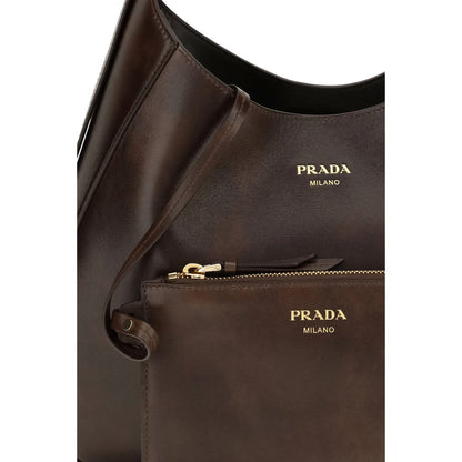 Medium Shoulder Bag by Prada for women in bos taurus calf leather brown features a distinguished silhouette, showcasing a secure zipper & magnetic and distinguished with versatile shoulder-strap, adjustable-strap & handle for a distinguished finish.