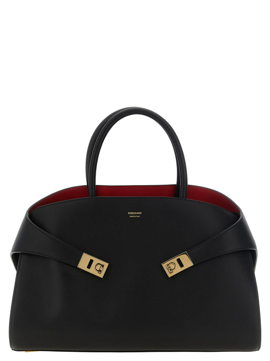 Handbag by Ferragamo for women in calfskin leather black, gold & red features a contemporary silhouette, showcasing a secure buckle, ample , and contemporary shoulder-strap, adjustable-strap & handle for a sophisticated look.
