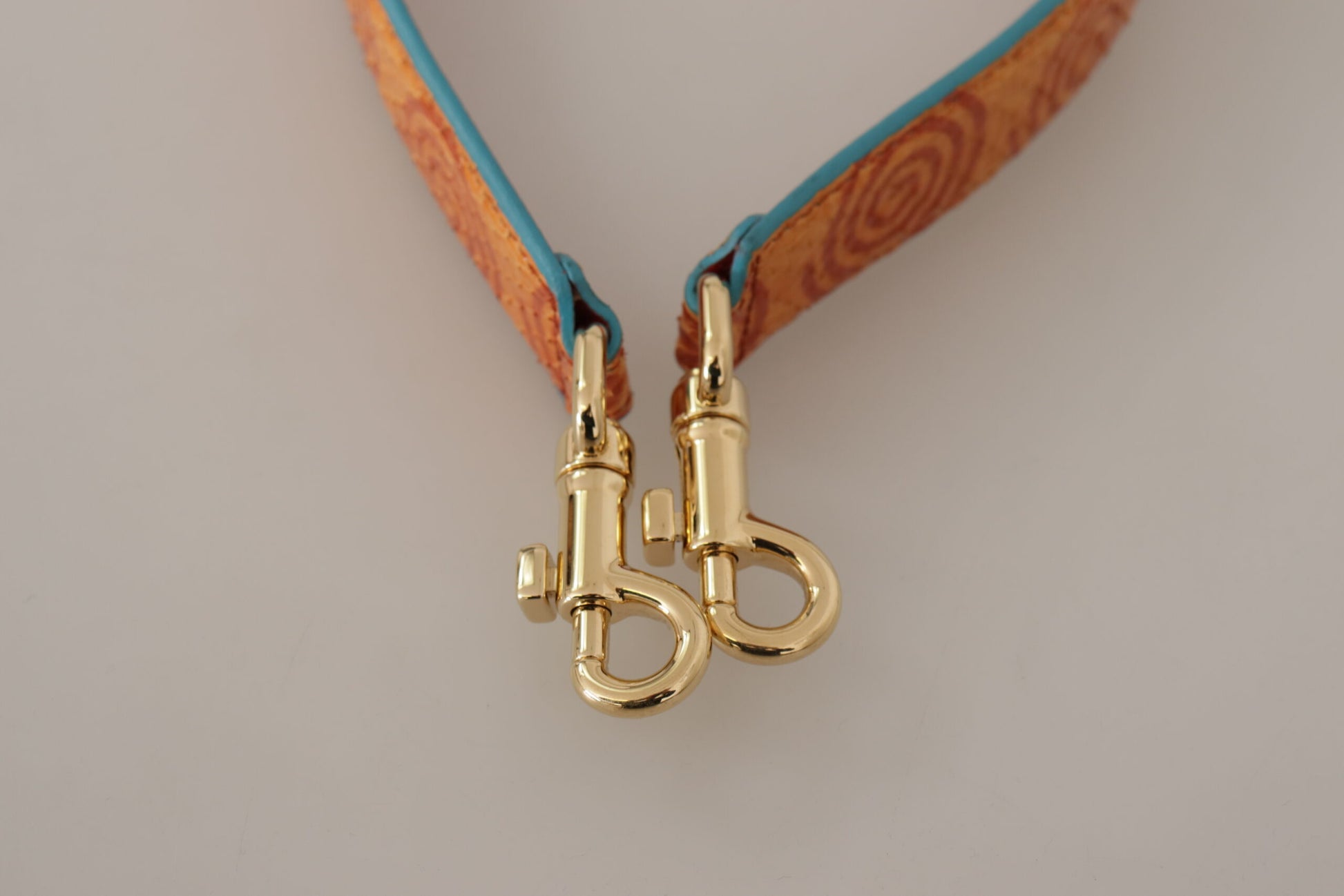 Shoulder Strap by Dolce & Gabbana for unisex in leather & metal gold, orange & print features a dynamic silhouette, artfully enhancing the dynamic design of this Leather Metal Shoulder Strap.