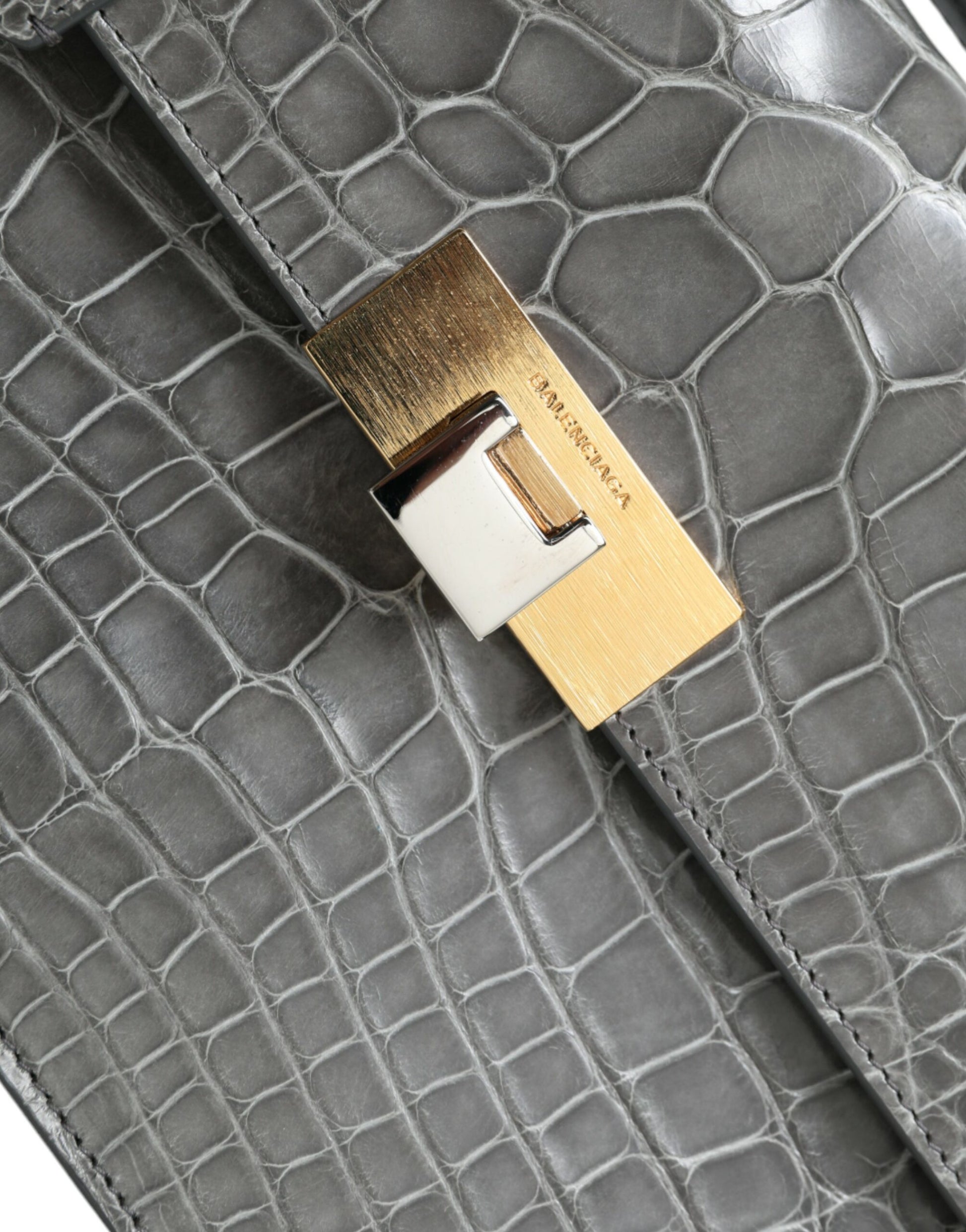 Medium Shoulder Bag by Balenciaga for women in alligator skin leather gray features a effortless chic silhouette with a secure magnetic, ample , and versatile shoulder-strap, adjustable-strap, detachable-strap & handle for a effortless chic finish.