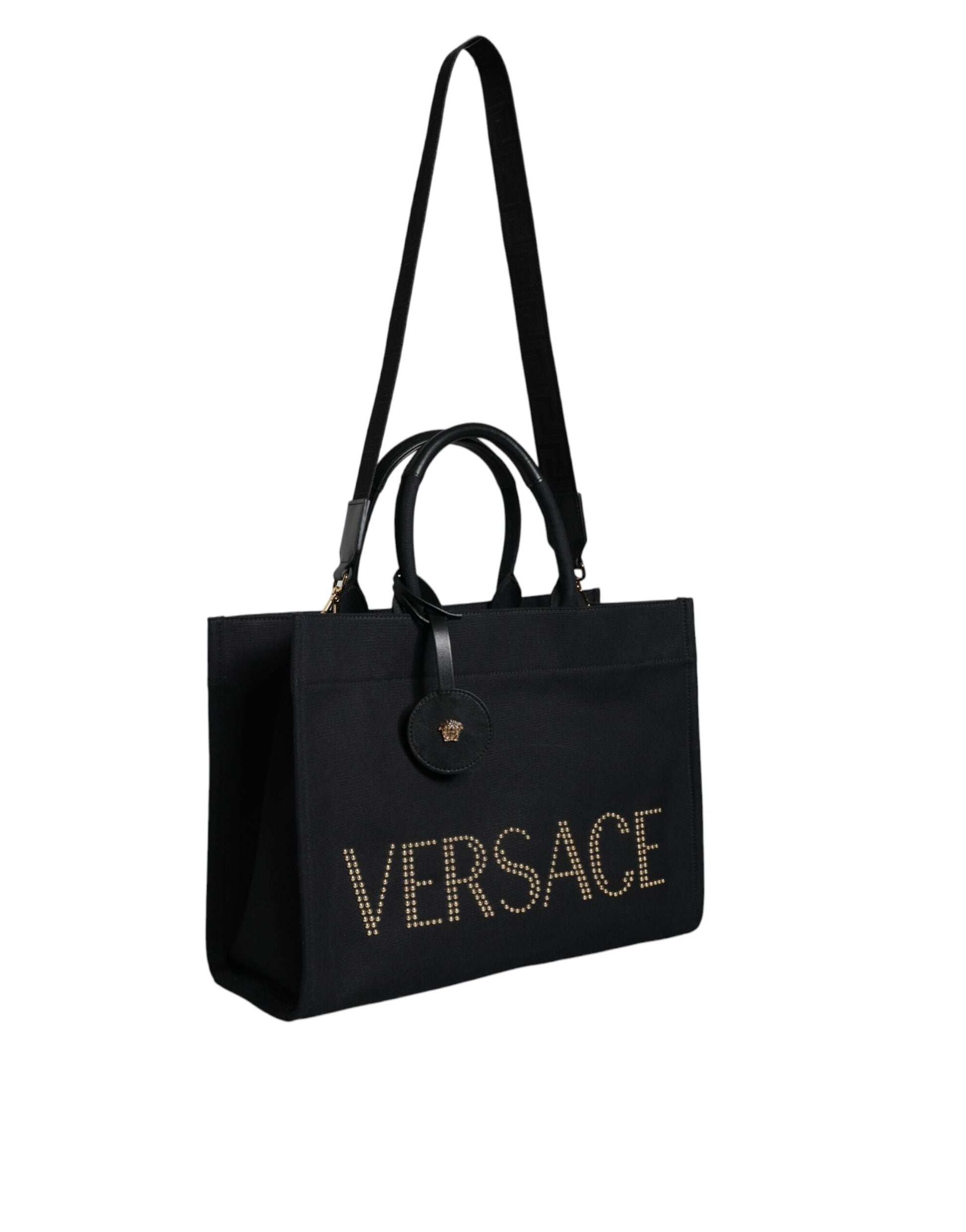 This Crossbody Tote Bag by Versace for women in canvas & leather black features an jet-set Canvas & Leather Crossbody Tote Bag design with a secure zipper, ample , and jet-set crossbody-strap, shoulder-strap, handle, adjustable-strap & detachable-strap.