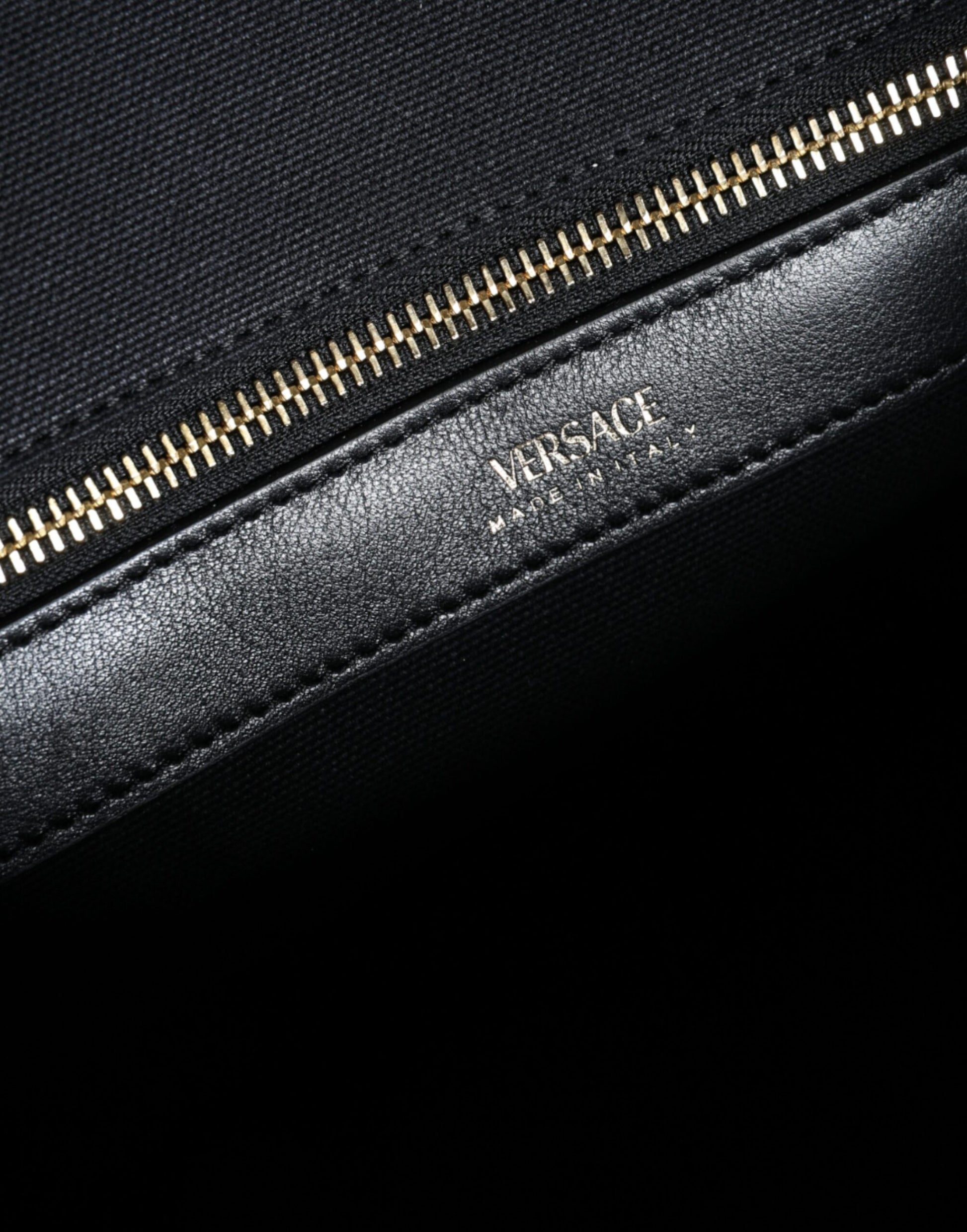 Crossbody Tote Bag by Versace for women in canvas & leather black features an jet-set-ready silhouette, showcasing the Canvas & Leather Crossbody Tote Bag design with a secure zipper, ample , and versatile crossbody-strap, shoulder-strap, handle, adjustable-strap & detachable-strap.