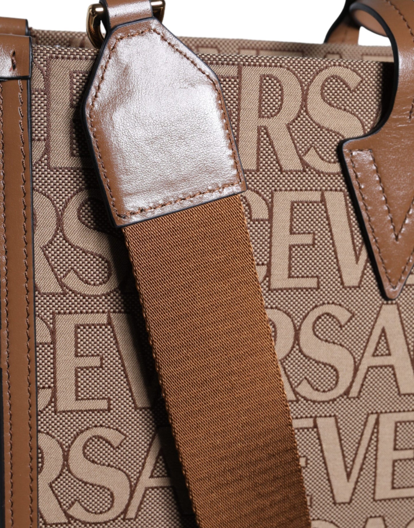 Crossbody Tote Bag by Versace for women in leather & cotton brown, white & jacquard features an jet-set-ready silhouette, showcasing the Leather & Cotton Crossbody Tote Bag design with a secure zipper, ample , and versatile crossbody-strap, shoulder-strap, handle, adjustable-strap & detachable-strap.