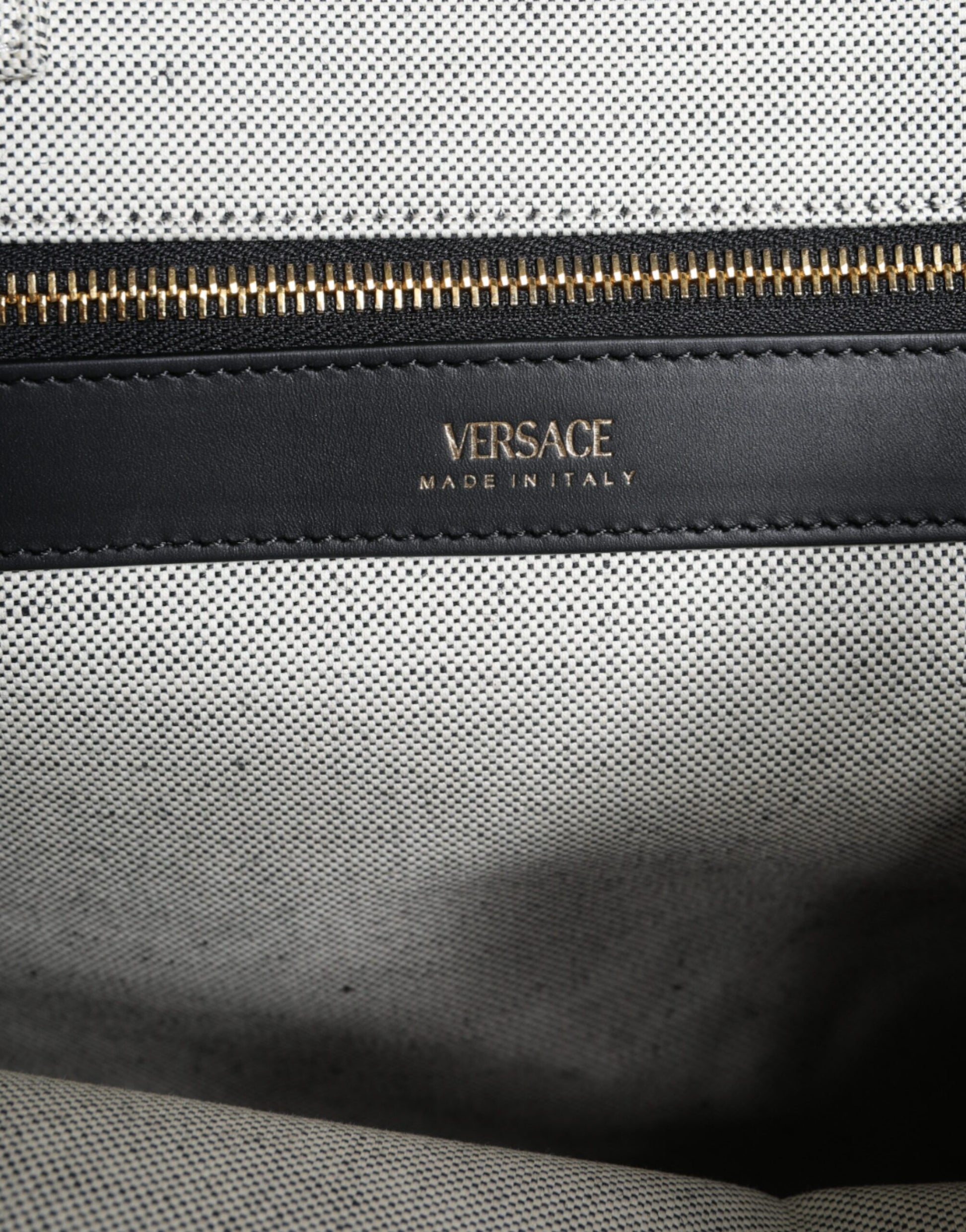Crossbody Tote Bag by Versace for women in leather & canvas black & white features an jet-set Crisp Leather & Canvas Crossbody Tote Bag design with a secure zipper, ample , and versatile crossbody-strap, shoulder-strap, handle, adjustable-strap & detachable-strap for an jet-set finish.