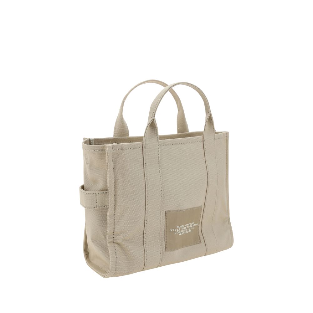 This Medium Tote Handbag by Marc Jacobs for women in cotton and beige, signature, monogram & print presents a sculptural silhouette featuring a secure zipper, ample , and versatile shoulder-strap, handle & adjustable-strap for a sculptural finish.
