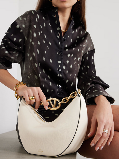 Small 2-in-1 Shoulder & Crossbody Hobo Convertible Handbag by Valentino Garavani for women in calfskin leather black, ivory & signature presents a enviable design with a secure , ample , and versatile crossbody-strap & shoulder-strap for a sophisticated look.
