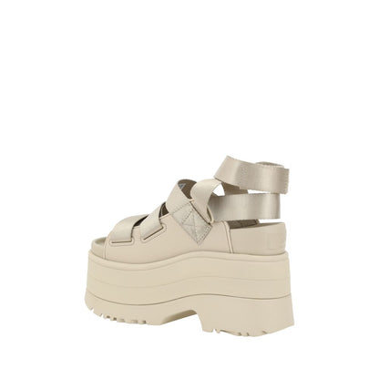 Platform Sandals by UGG for women in rubber beige showcases a sculptural silhouette as Women's Rubber Platform Sandals, defined by a sculptural platform and sculptural round toe style for a sculptural look.