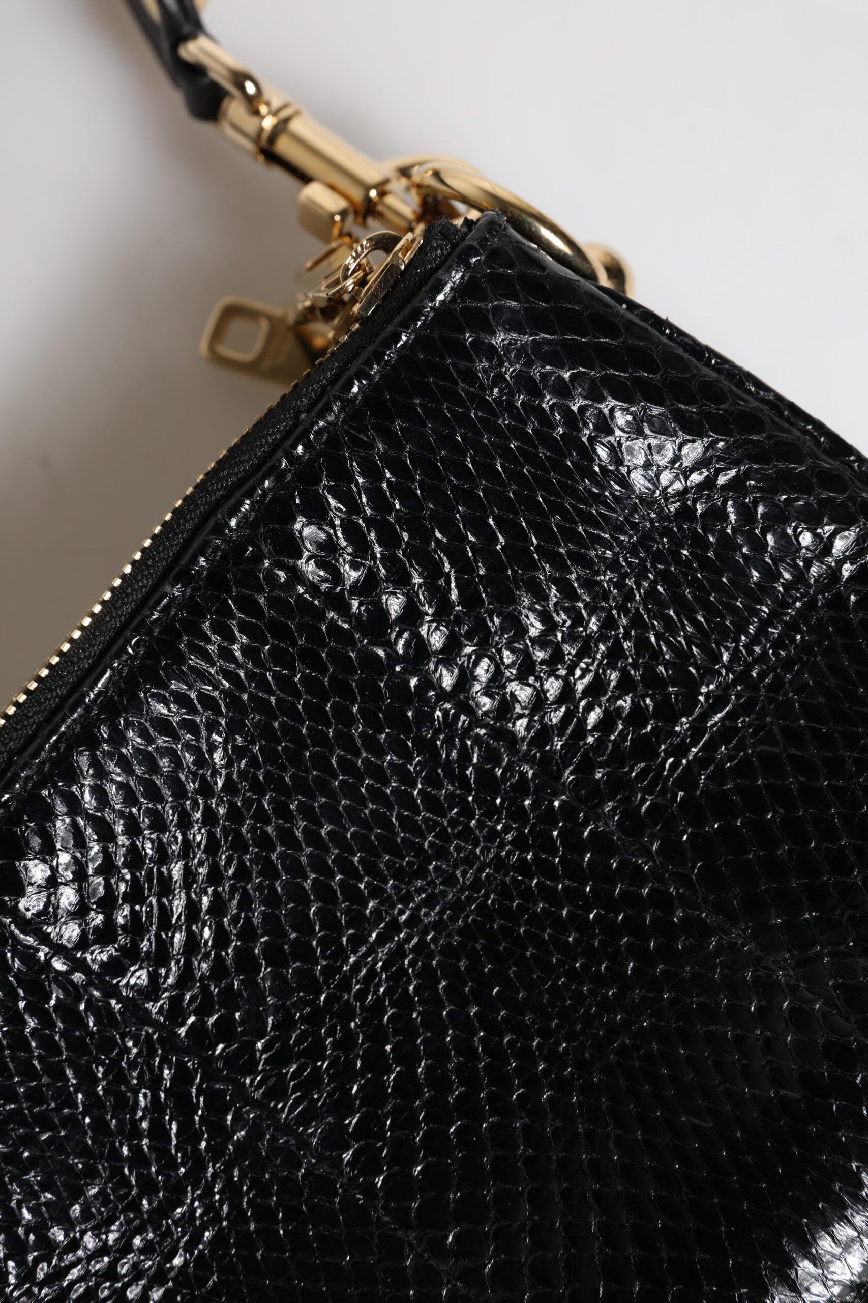 Shoulder Sling Clutch Bag by Dolce & Gabbana for women in exotic leather black & gold features a effortless sophistication silhouette, secured by a zipper with ample and versatile shoulder-strap, adjustable-strap & detachable-strap for a effortless sophistication finish.