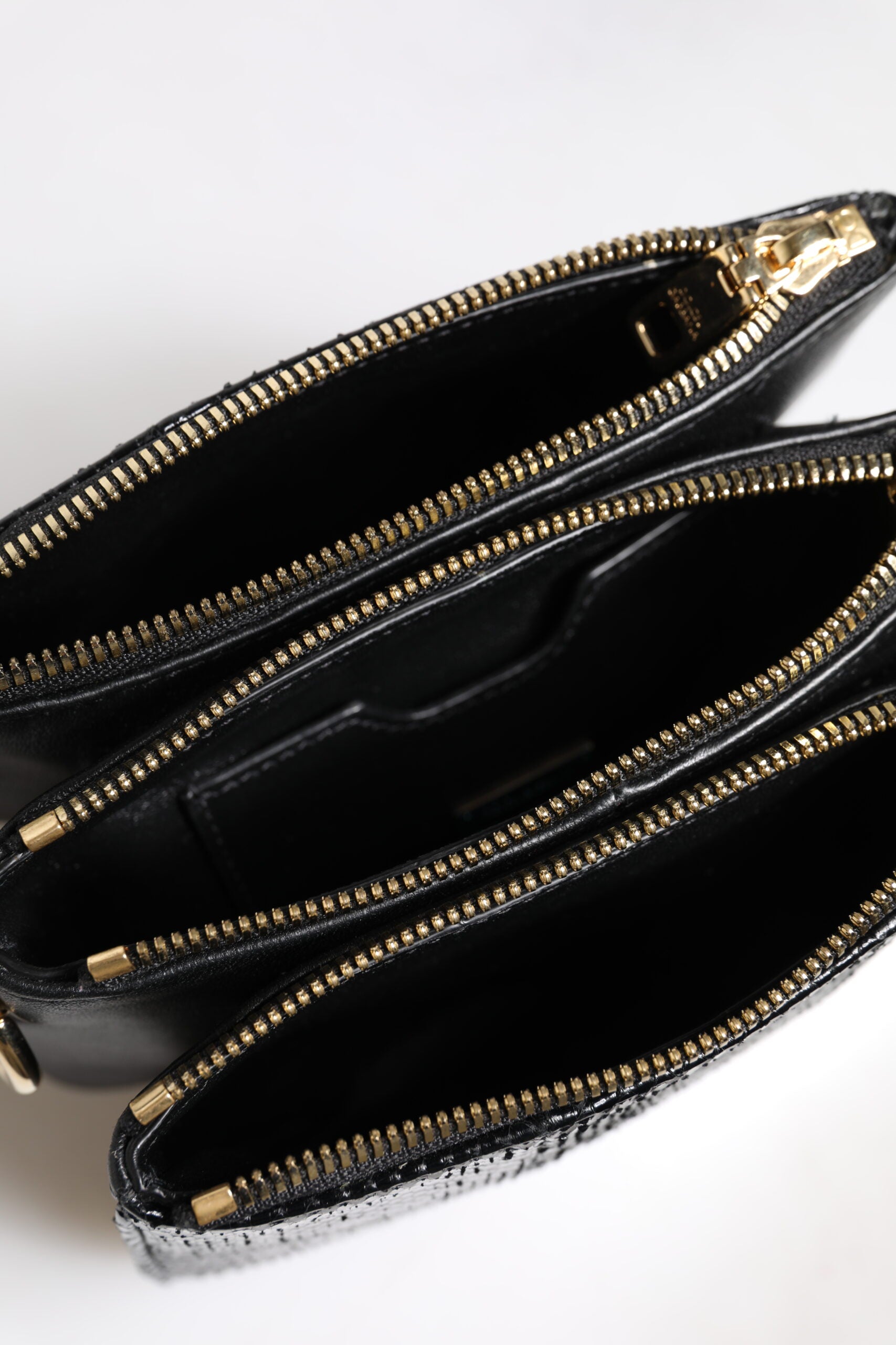 Shoulder Sling Clutch Bag by Dolce & Gabbana for women in exotic leather black & gold features a statuesque silhouette, showcasing a secure zipper and statuesque with versatile shoulder-strap, adjustable-strap & detachable-strap for a statuesque finish.