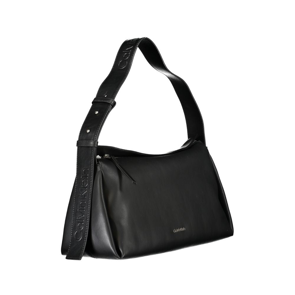 Convertible Handbag by Calvin Klein for women in polyester faux leather black features a polished silhouette with a secure zipper, ample internal-pockets, and polished shoulder-strap, adjustable-strap & handle for a sophisticated look.