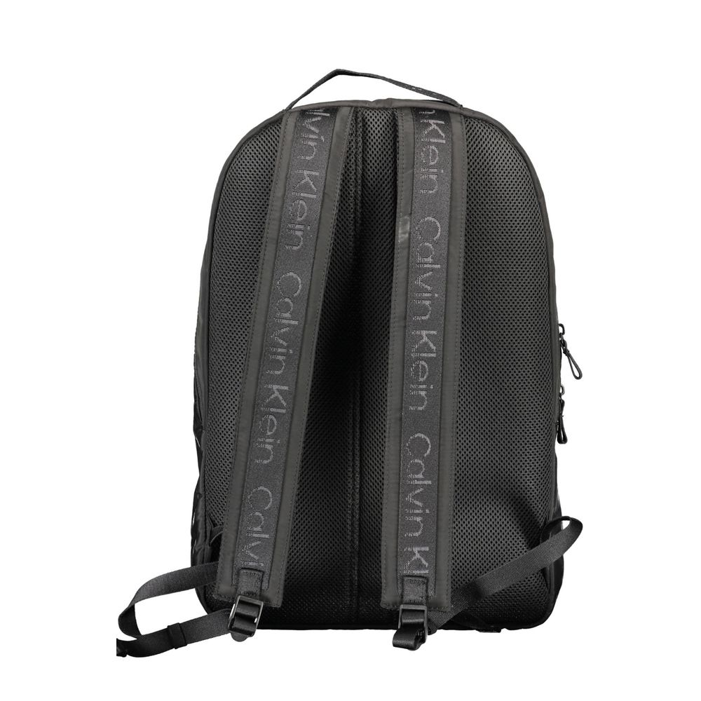 Backpack by Calvin Klein for men in polyester black showcases an architectural Polyester Backpack design, featuring a secure zipper, ample external-pockets, internal-pockets & laptop-compartment, and architectural backpack-strap, adjustable-strap & handle for a sophisticated look.