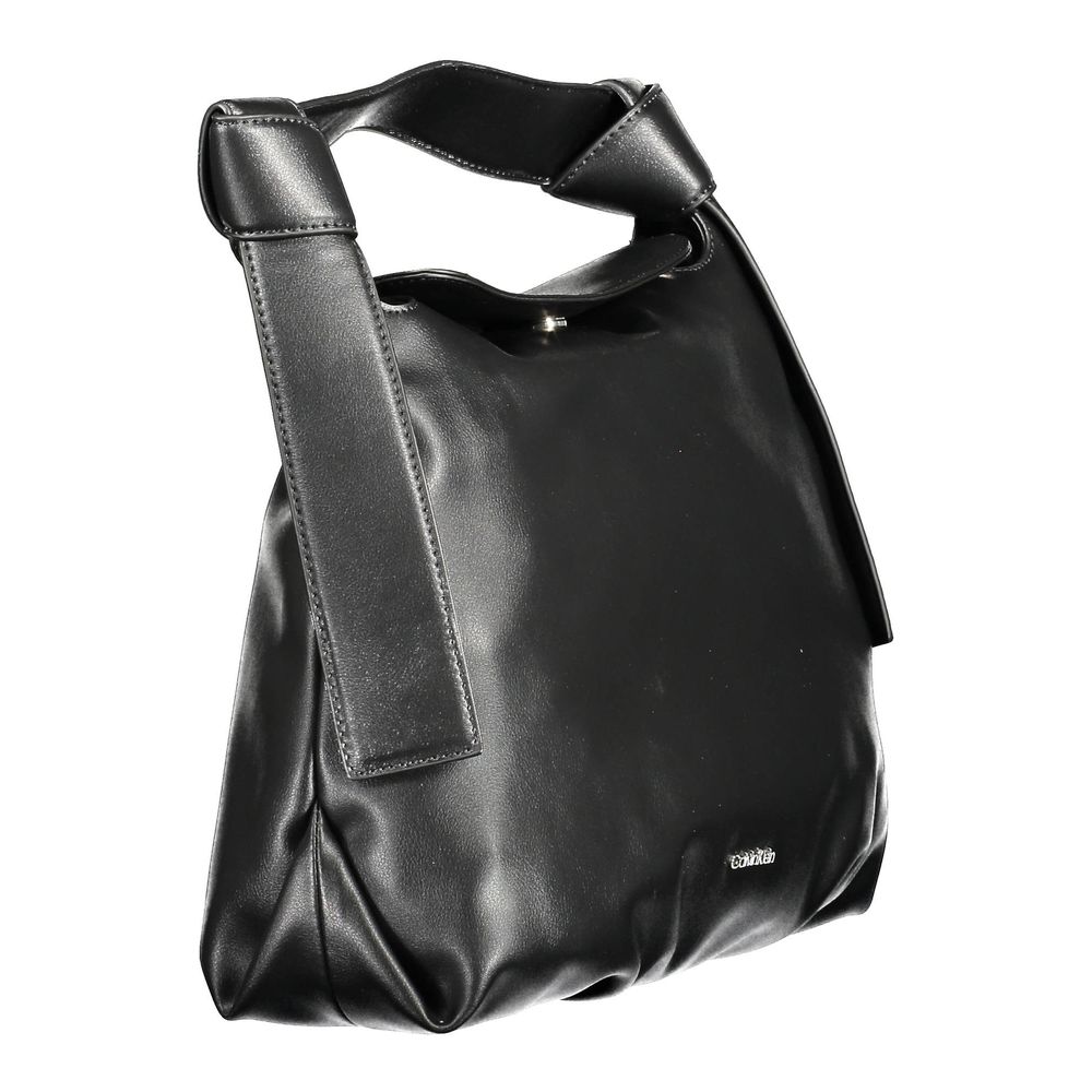 Satchel Handbag by Calvin Klein for women in polyester faux leather black features a signature silhouette, showcasing a secure snap and signature internal-pockets with versatile shoulder-strap, adjustable-strap & handle for a sophisticated look.