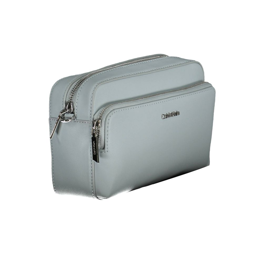 This Crossbody Handbag by Calvin Klein for women in polyester faux leather and blue presents a sculptural silhouette featuring a secure zipper, ample internal-pockets, and versatile crossbody-strap & adjustable-strap for a sculptural finish.