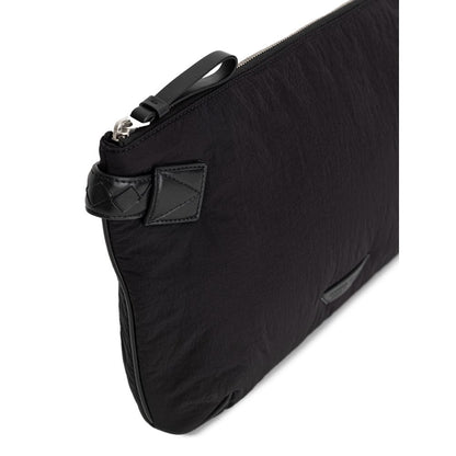 Clutch Handbag by Bottega Veneta for men in nylon & leather black features a sculptural silhouette with a secure zipper, ample single-compartment & internal-pockets, and versatile handle for a sculptural finish.