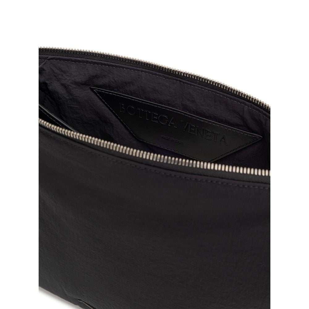 Clutch Handbag by Bottega Veneta for men in nylon & leather black features a sculptural silhouette with a secure zipper, organized single-compartment & internal-pockets, and versatile handle for a sculptural finish.