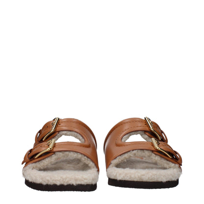 Flat Clogs Sandals by Valentino Garavani for women in leather & rubber brown features an exquisite silhouette, showcasing the exquisite Women's Leather & Rubber Flat Clogs Sandals with a flat and almond open toe style.