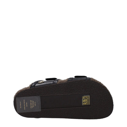 Flat Clogs Slippers by Valentino Garavani for women in leather & rubber black presents a sumptuous silhouette, perfectly capturing the sumptuous essence of Women's Leather & Rubber Flat Clogs Slippers with its signature open toe style and flat.