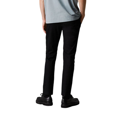 Pants by Calvin Klein Jeans for men in stretch cotton black features a sleek silhouette with a sleek tapered-leg & regular-fit, a refined long, and a sophisticated finish.