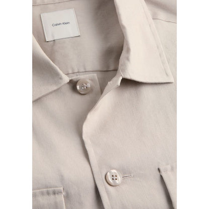 Overcoat by Calvin Klein for men in stretch linen & lyocell beige showcases a architectural silhouette, artfully detailed with a distinctive and functional breathable-design, lightweight & pockets for a architectural finish.