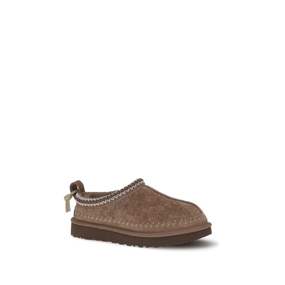Mules Flat Shoes by UGG for women in suede leather & rubber brown showcases a stalwart silhouette, artfully capturing Women's Suede Leather & Rubber Mules Flat Shoes through its distinctive and elegant .
