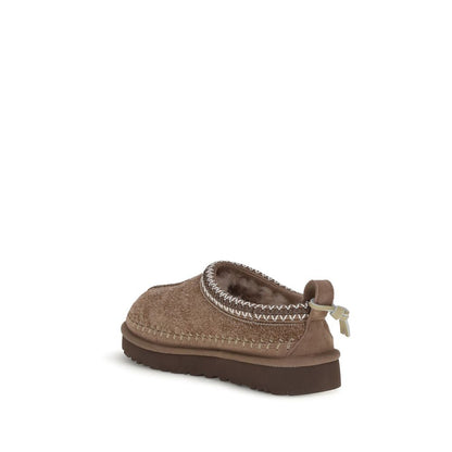 Mules Flat Shoes by UGG for women in suede leather & rubber brown features an stately silhouette, showcasing the stately style of the Women's Suede Leather & Rubber Mules Flat Shoes with its distinct and refined .