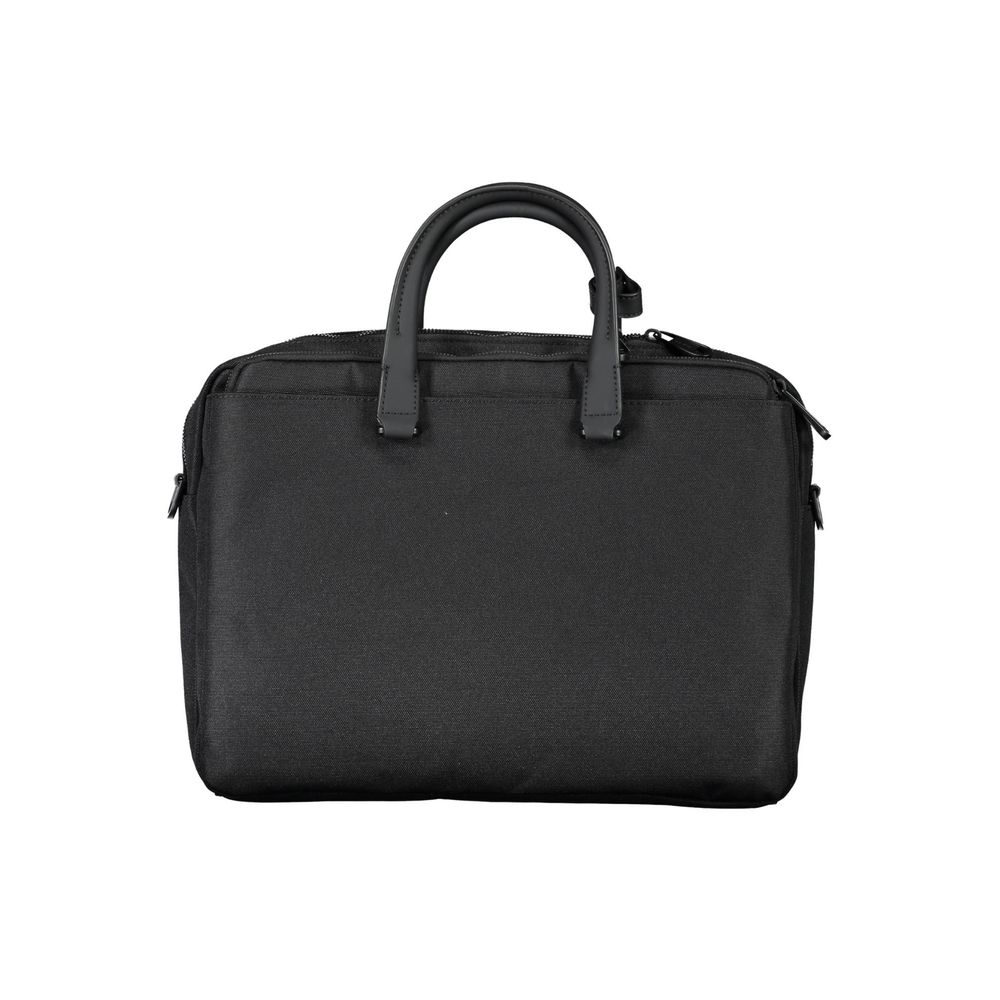 Briefcase Handbag by Calvin Klein for unisex in polyester black features an refined silhouette, showcasing a secure zipper, ample built-in-compartments, document-holder, external-pockets, internal-pockets & laptop-compartment, and versatile shoulder-strap, adjustable-strap & handle for a sophisticated refined aesthetic.